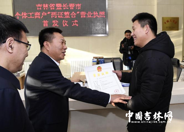 吉林省政府副秘书长高志国为高晓平颁发“两证整合”后第一本营业执照。